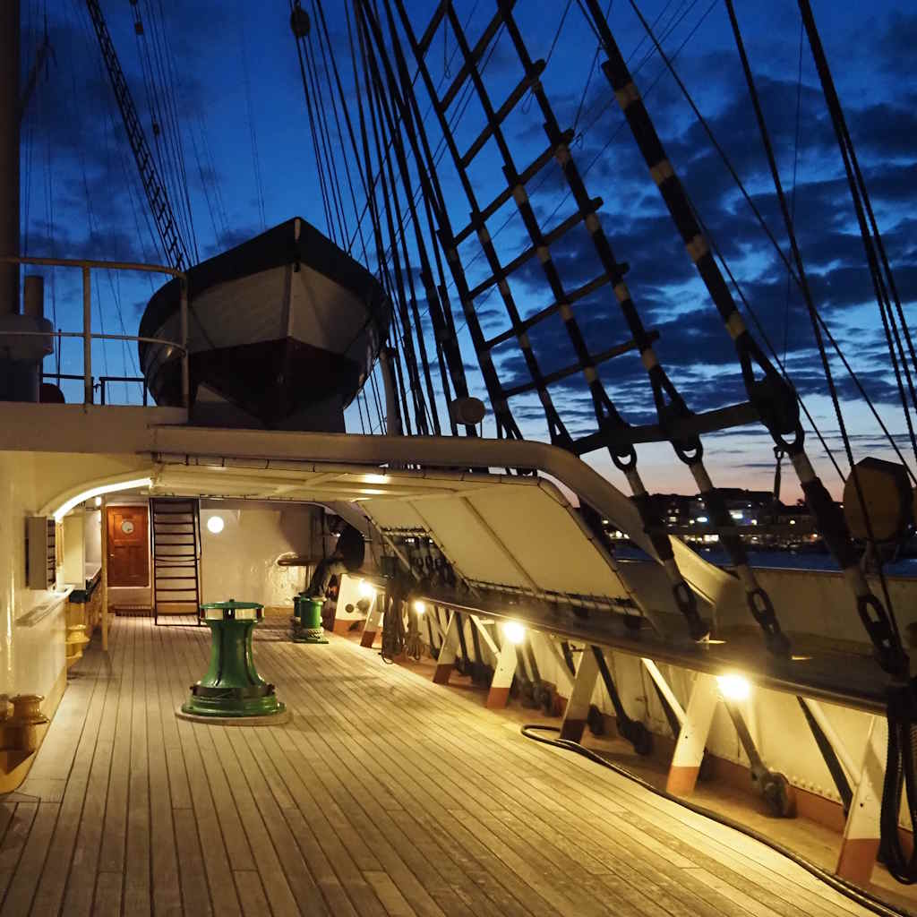 Schiffsdeck der Passat hell beleuchtet in der Dämmerung.