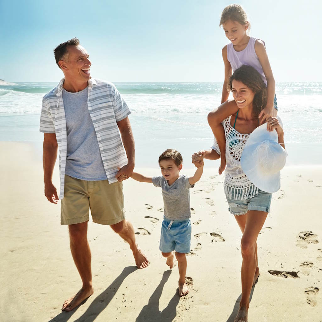 Familie mit Kinder geht am Strand spazieren
