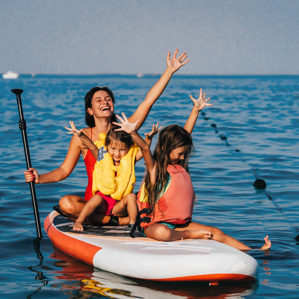 Frau mit Kindern auf SUP auf dem Meer