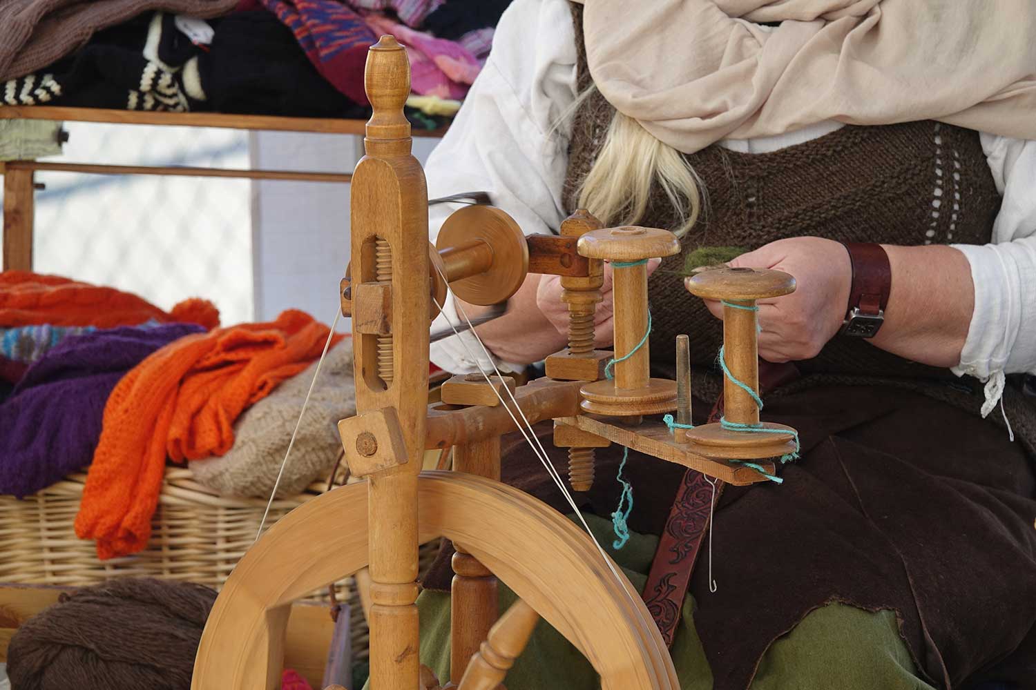 Hände einer Frau, die an der Spindel auf dem Mittelaltermarkt in Heide arbeitet.