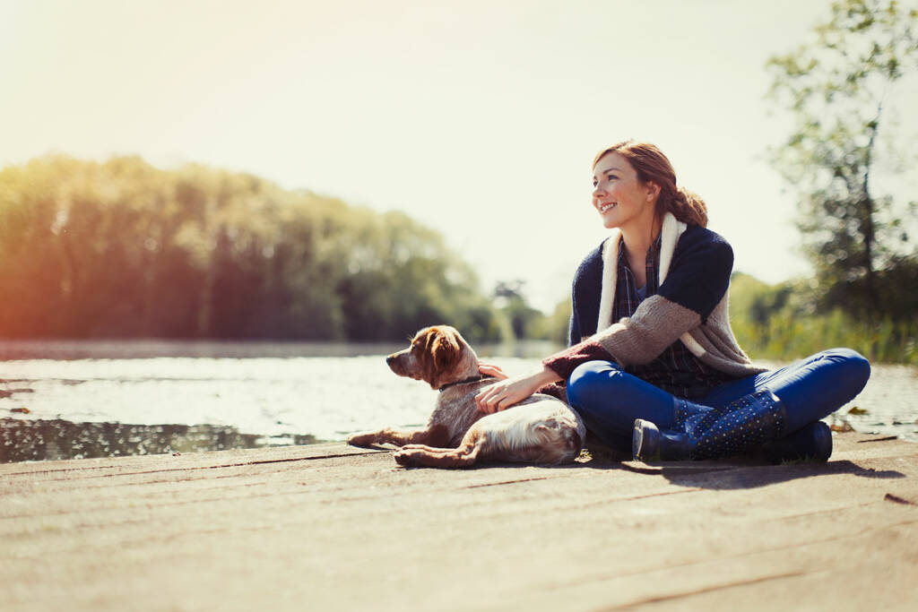 Frau mit Hund auf Steg am Westensee